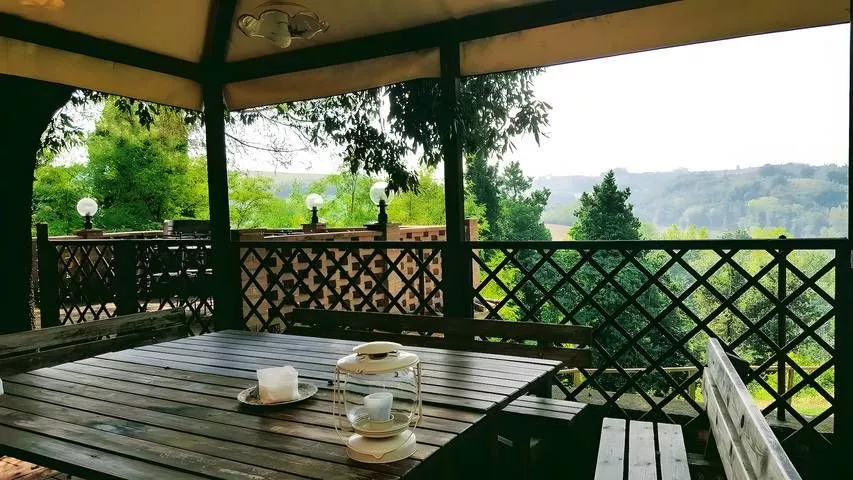 Breakfast table under wooden gazebo with countryside view at Podere Settefrati Tuscany