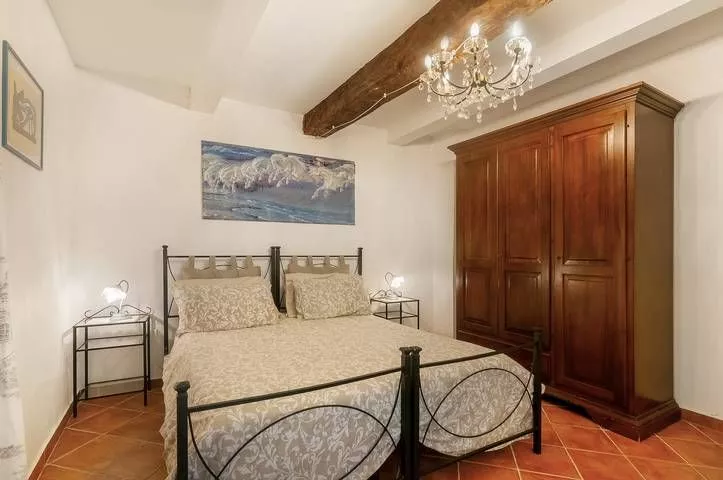 Bright bedroom with rustic beams and large wardrobe at Podere Settefrati Tuscany