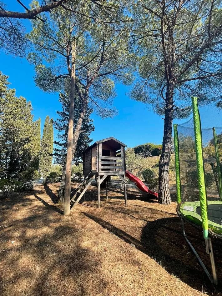 Children’s playground with slide and swings among trees at Podere Settefrati