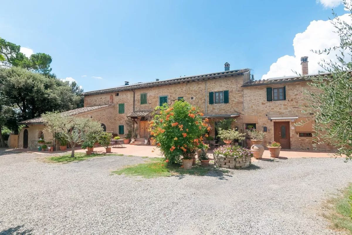 Courtyard view of Podere Settefrati surrounded by plants and rustic stone buildings