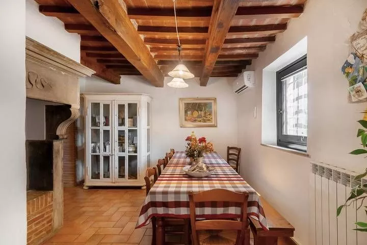 Dining room with rustic table and wooden ceiling at Podere Settefrati farmhouse