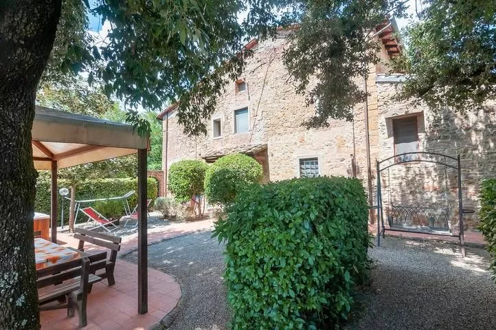 Garden patio with pergola and seating area at Podere Settefrati farmhouse