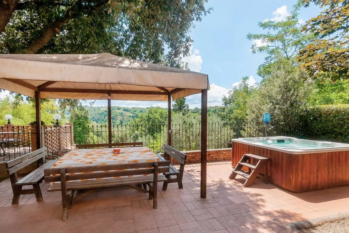 Jacuzzi area under pergola surrounded by greenery at Podere Settefrati farmhouse