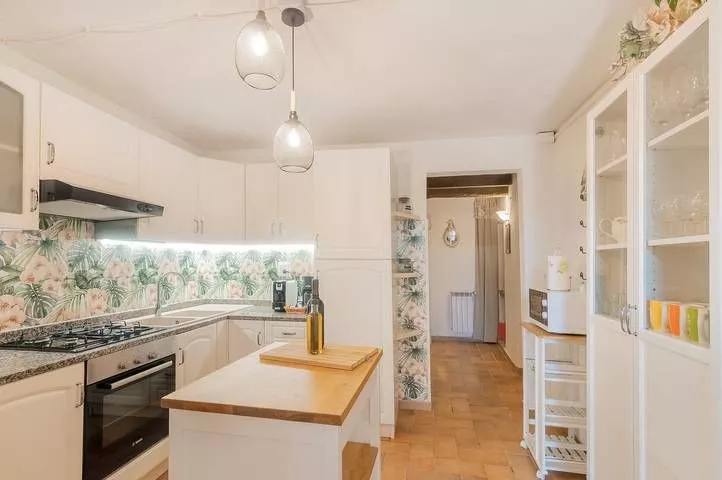 Modern kitchen area with tiled backsplash and wooden countertop at Podere Settefrati