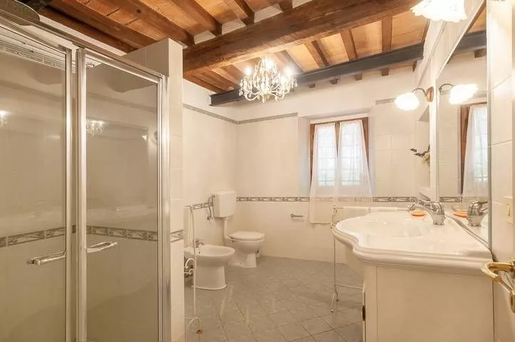 Large bathroom with wooden beams and classic decor at Podere Settefrati Tuscany