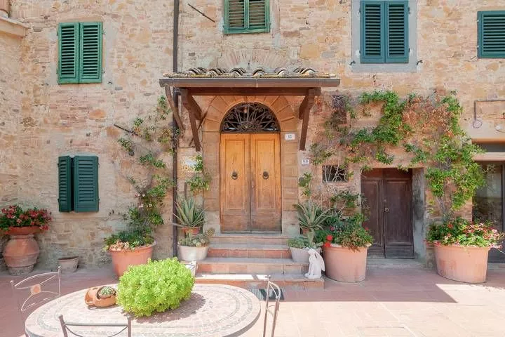 Main entrance of Podere Settefrati farmhouse with stone walls and wooden door