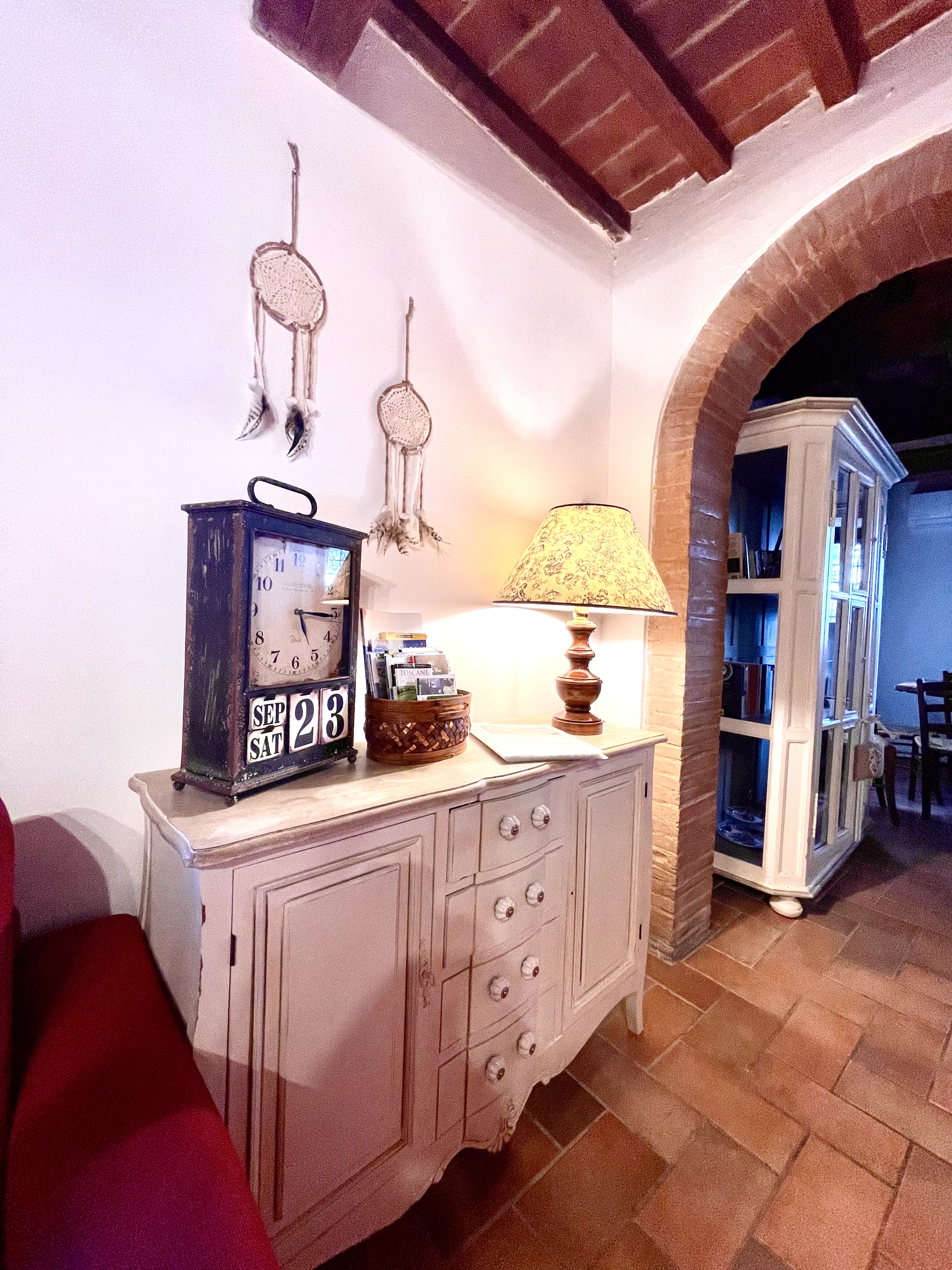 Rustic living room detail with arch, terracotta floor and wooden ceiling at Podere Settefrati farmhouse in Tuscany