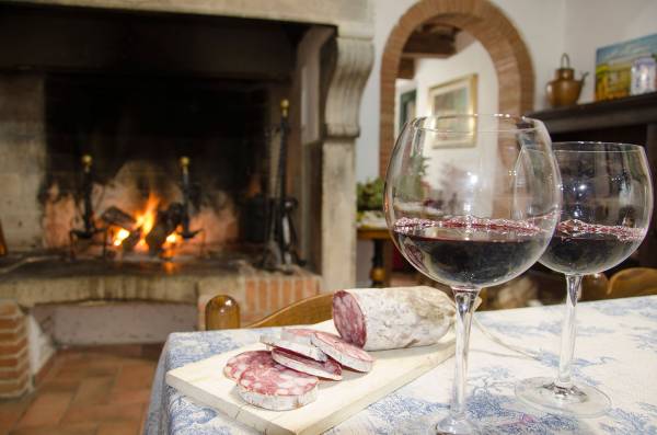 Living room with wooden beams and fireplace at Podere Settefrati