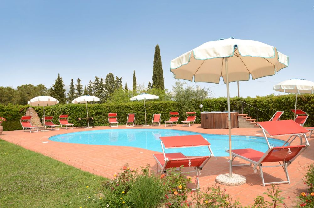 Pool area with sunbeds at Podere Settefrati in Tuscany