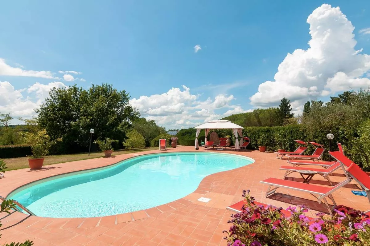 Outdoor swimming pool at Podere Settefrati with sun loungers, terracotta deck and countryside views in Montaione, Tuscany