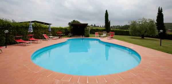 Shaded relax area and garden by the pool at Podere Settefrati Tuscany