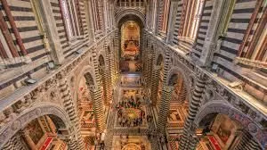 Interior of Siena Cathedral showcasing the striped marble columns and richly decorated nave