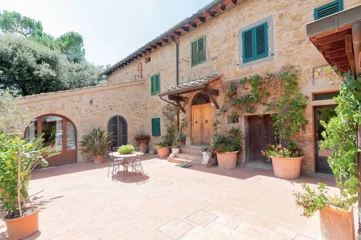Sunny terrace with arches and potted plants at Podere Settefrati farmhouse in Tuscany