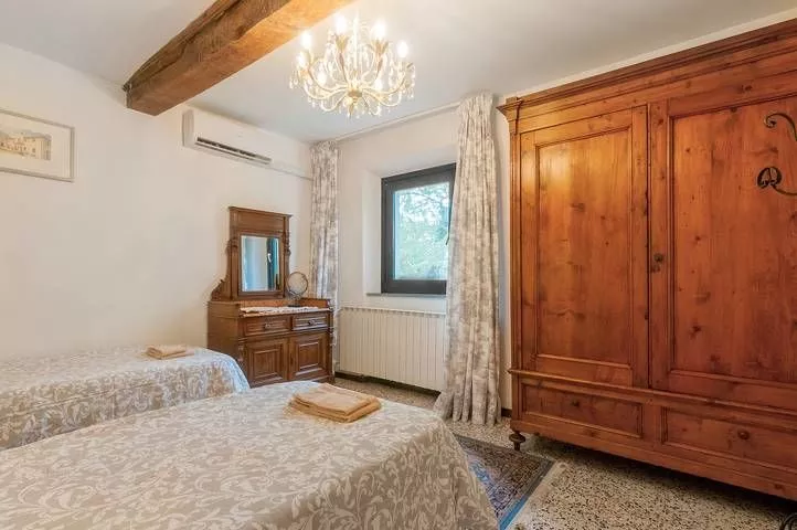 Twin bedroom with wooden furniture and countryside view at Podere Settefrati