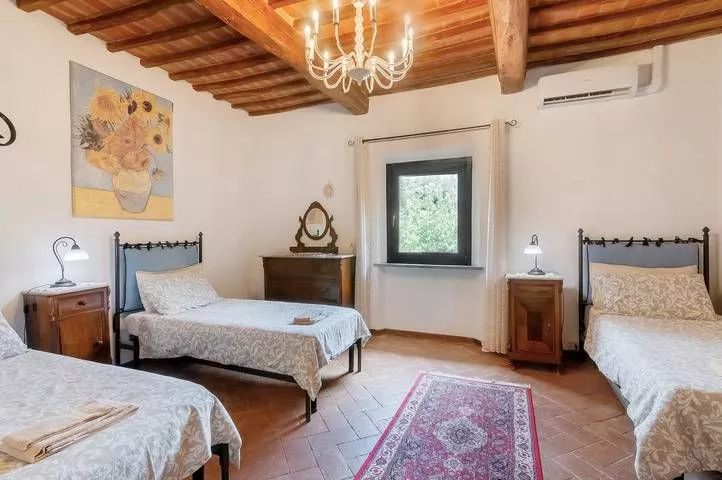 Twin bedroom with countryside view and rustic furniture at Podere Settefrati farmhouse